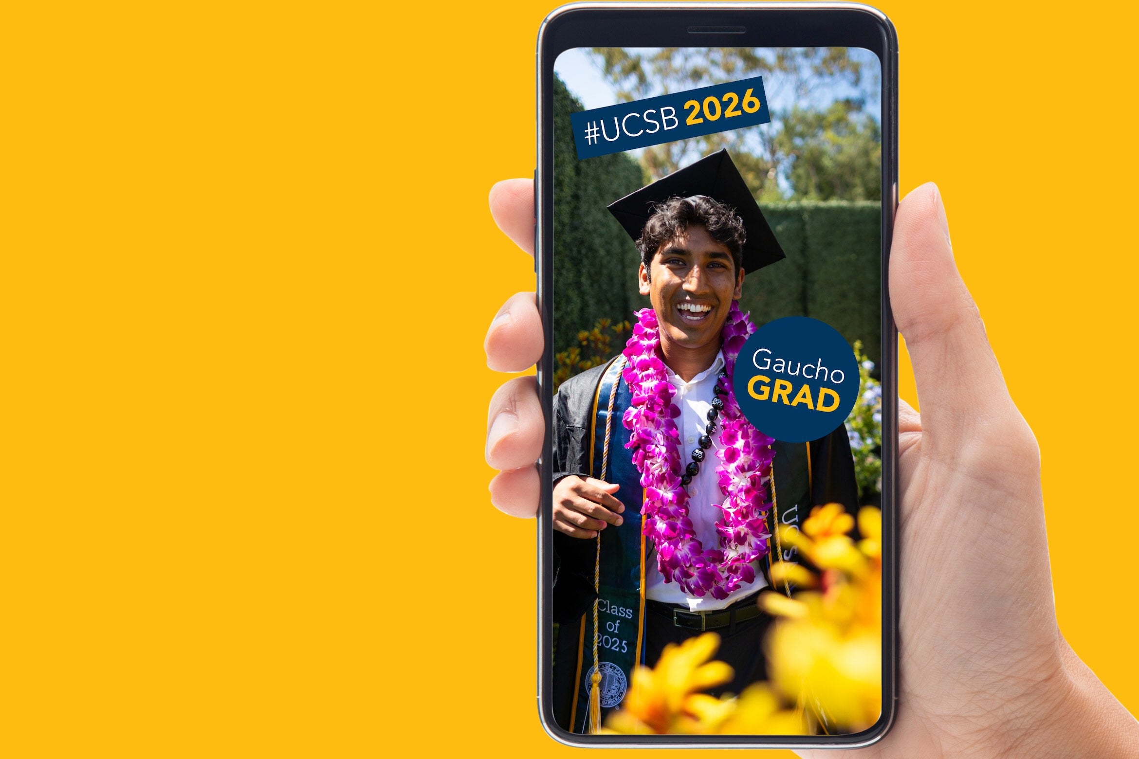 Gaucho graduate holding phone to entice visitors to this site to use the GIPHY stickers