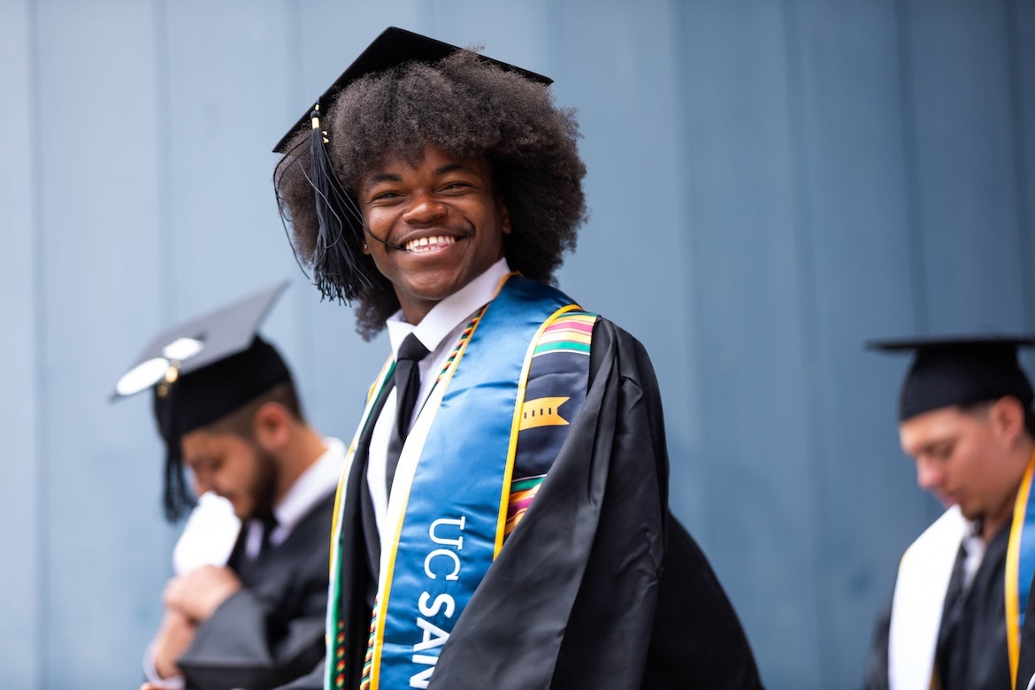A graduating student smiling